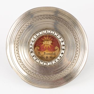a silver plate with a picture of a sun on it