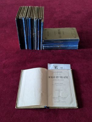 Plusieurs livres sont empilés sur une table recouverte d'une nappe rouge.