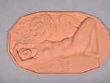 un gros plan sur une sculpture en argile représentant une femme allongée sur un lit