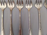 six forks and spoons are arranged in a row on a table