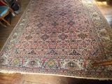an antique persian rug on a wooden floor in a room