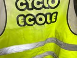 a man holding up a yellow vest that says cyclecool