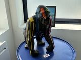 une statue représentant un gorille assis sur un tonneau