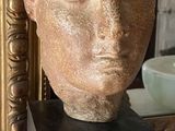 a statue of a woman ' s head sitting on a table