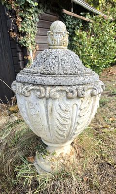 une grande urne blanche posée dans l'herbe