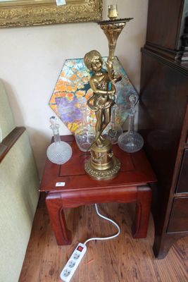 une petite table sur laquelle est posée une lampe, à côté d'une chaise