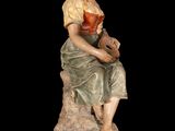 statue of a woman sitting on a rock holding a guitar