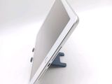 a tablet computer sitting on a stand on a white surface