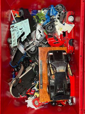 a red box filled with assorted toy cars
