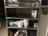 une cuisine équipée d'étagères en inox et où l'on trouve beaucoup de provisions