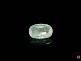 a close up of a green diamond on a black surface