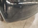 a man standing next to a car in a garage