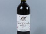 a bottle of red wine with a gold cap on top