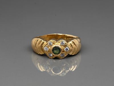 a close up of a gold ring with a green and white stone