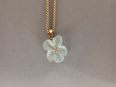 yellow gold chain with a flower pendant and a pearl bead