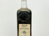a close up of a bottle of liquor on a white surface