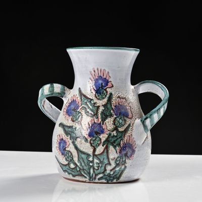 un vase blanc orné de fleurs bleues, posé sur une table