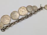 a close up of a chain bracelet with coins on it