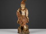 une figurine sculptée représentant un homme assis sur une souche d'arbre