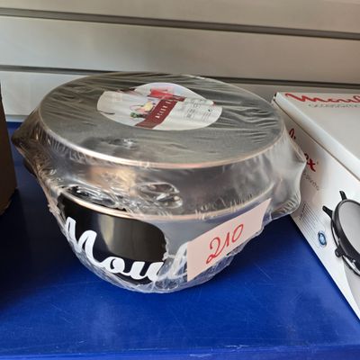 un récipient en plastique posé sur une table, à côté d'une boîte