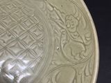 a green plate with a design on it sitting on a table