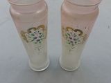two vases sitting on a table with a white table cloth