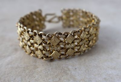 gros plan d'un bracelet en or sur une table