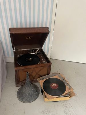 un vieux tourne-disque posé par terre à côté d'une lampe