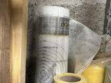 many rolls of tape sitting on the ground next to a building