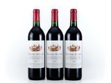 three bottles of red wine sitting next to each other on a white surface