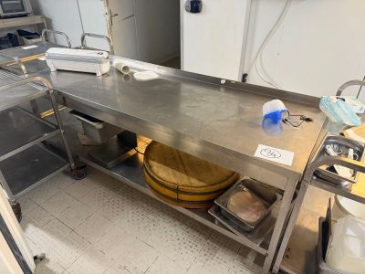 a large stainless steel table in a kitchen with a lot of dishes on it