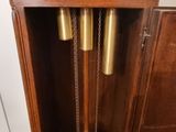 a wooden grandfather clock that is hanging on the wall