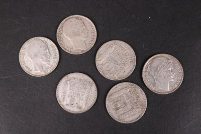 six pièces d'argent sont disposées en cercle sur une surface noire