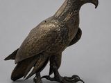 une image représentant une statue en bronze d'un oiseau sur fond gris