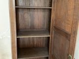 a wooden cabinet with a door open in a room