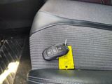 a car key on the seat of a car with a yellow tag attached to it