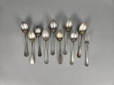 six spoons and a fork arranged in a row on a table