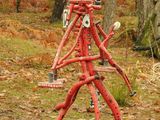 a red sculpture that is in the middle of the woods