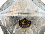 a clear glass vase with a gold and blue label on it