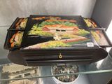 a black suitcase with a painting on it in a glass case