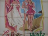 une vieille affiche de cinéma représentant deux femmes en maillot de bain sur la plage
