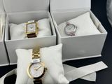 three watches in a box on a table with a bow tie