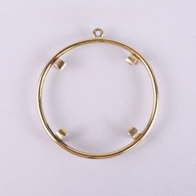 un cercle en métal plaqué or comportant quatre petits carrés à l’intérieur