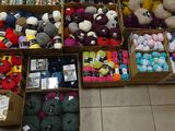 several boxes filled with lots of different colored balls of yarn
