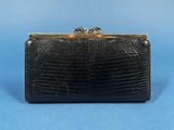 a black clutch bag with two gold rings on top of it