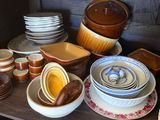 many different types of dishes and bowls on the shelf