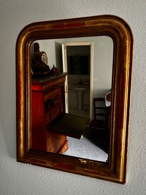 un miroir accroché au mur au-dessus d'une commode