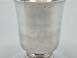 a close up of a silver cup on a white surface