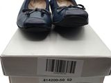 une paire de chaussures pour femme dans une boîte posée sur une surface blanche