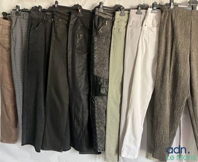 cinq pantalons suspendus à un portant